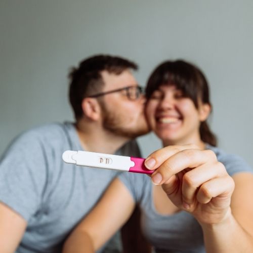 couple smiling with pregnancy test