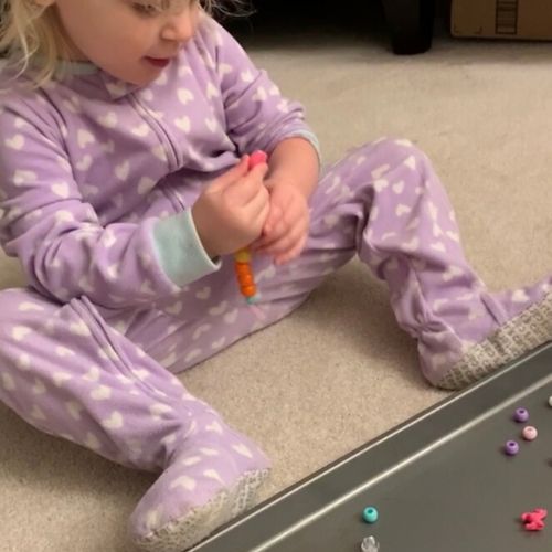 toddler playing with beads