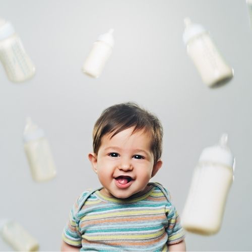 baby smiling with milk bottles