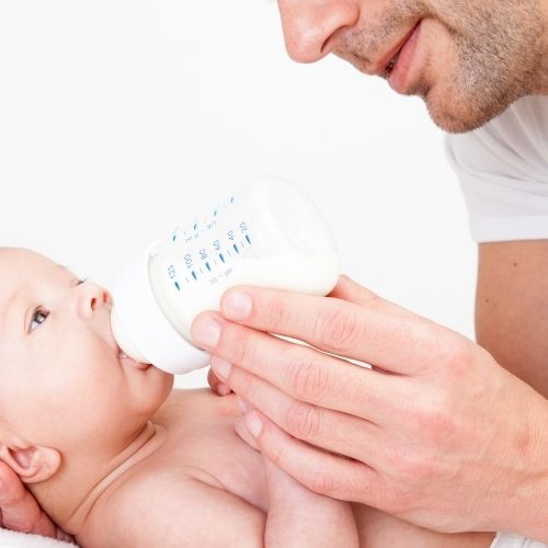 dad giving baby bottle