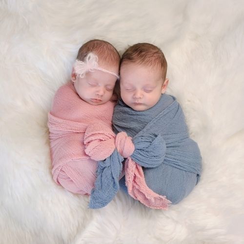 bOY AND GIRL BABY swaddled and cuddling