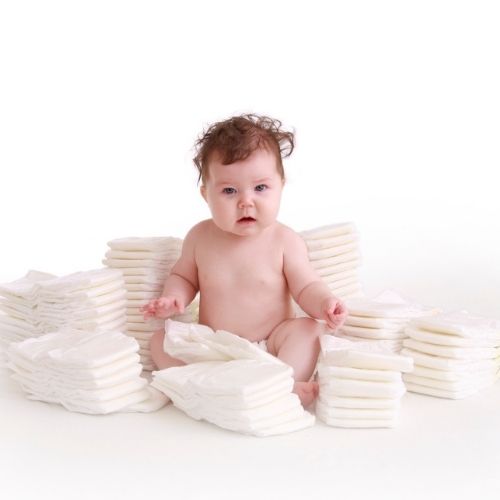baby sitting in diaper pile
