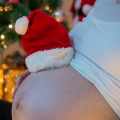 pregnant belly with santa hat on top 