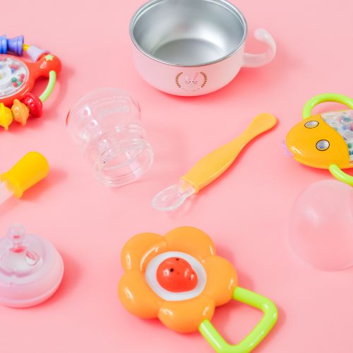 various teething and baby feeding items scattered along solid colored backdrop