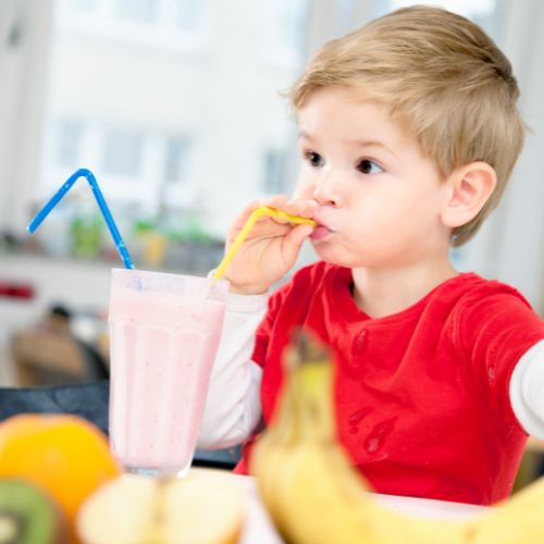 toddler boy drinking smoothie from a straw 