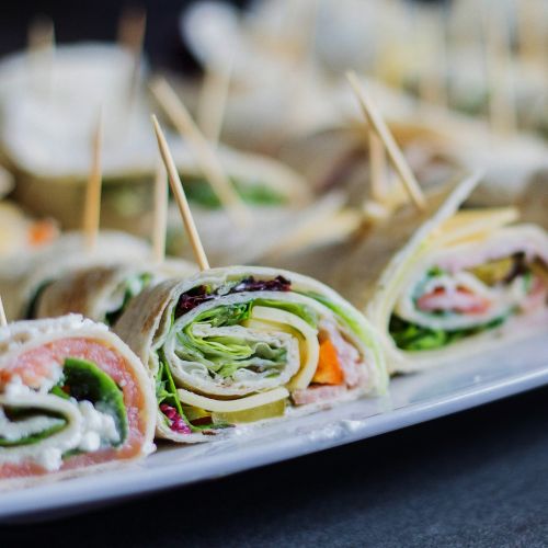 deli wraps rolled up with vegetables, meat and cheese and thinly sliced into pinwheels held together with a toothpick