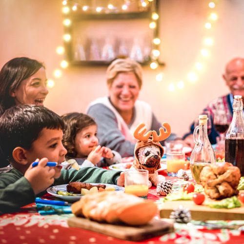a family gathered around a holiday table smiling and laughing