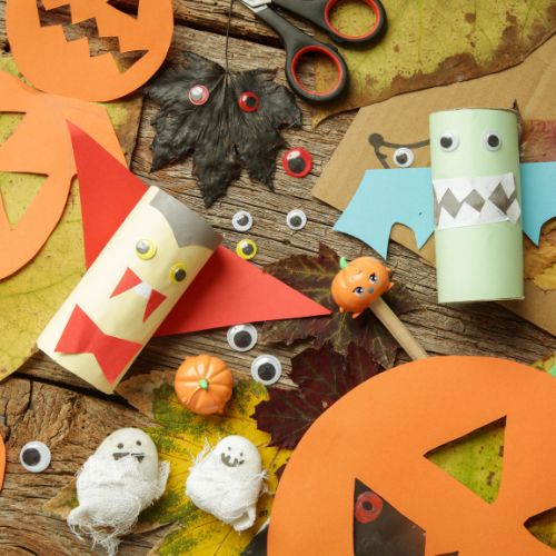 halloween crafts made by kids scattered across the table
