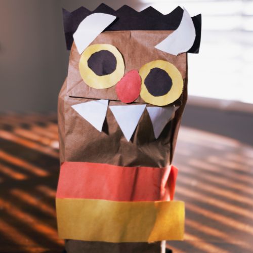 a paper bag with pieces of cut up construction paper glued on to make a silly monster face with googly eyes