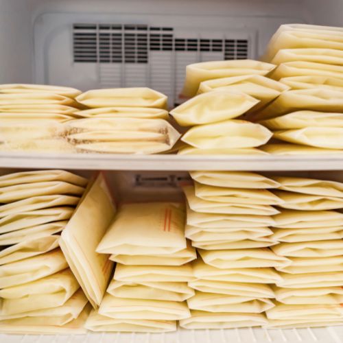 an open freezer door with stacks of frozen breastmilk 